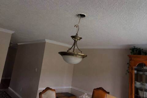 Ceiling fixture hanging on its wires below an open junction box