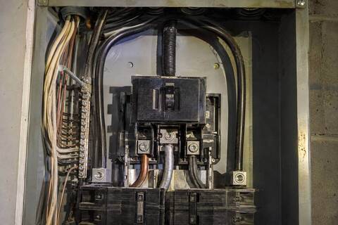 Main breaker and heavy service conductors at the top of a panel