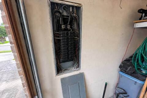 Breaker panel with the dead front removed, breakers and branch wiring visible inside
