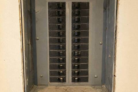 Row of breakers in a panel with one handle sitting between the on and off positions