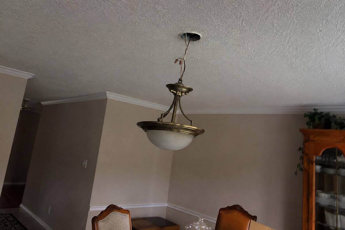 Ceiling fixture hanging on its wires below an open junction box
