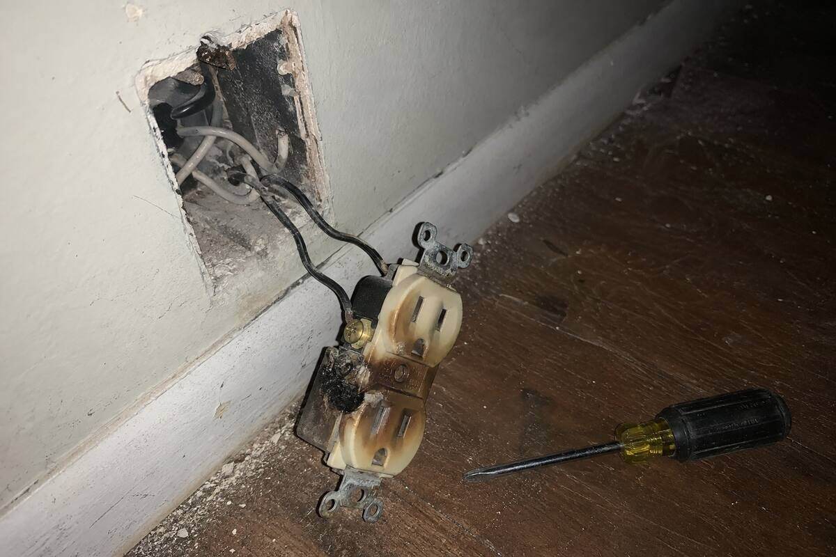 Discolored receptacle out of a wall box with darkened terminal screws